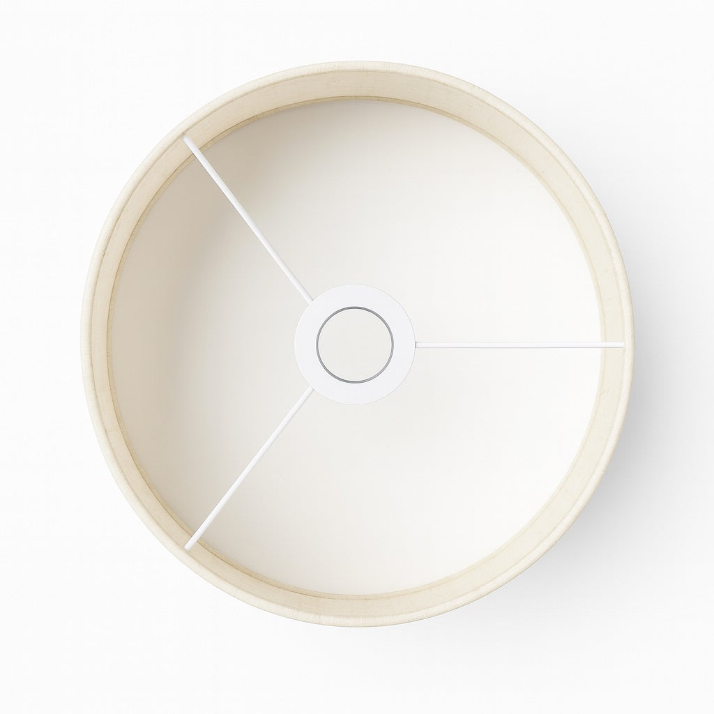 Vue du dessus d’un abat-jour tambour beige en tissu pour lampadaire, structure métallique blanche.
