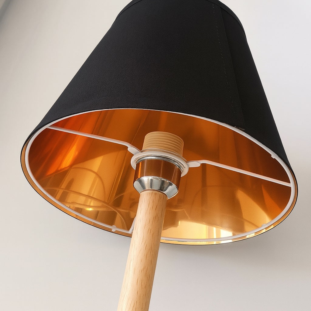 Abat-jour conique noir avec intérieur cuivré, parfait pour une lampe design et chaleureuse.