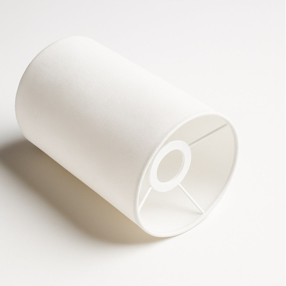Vue en angle d’un abat-jour cylindrique en tissu blanc avec armature intérieure discrète