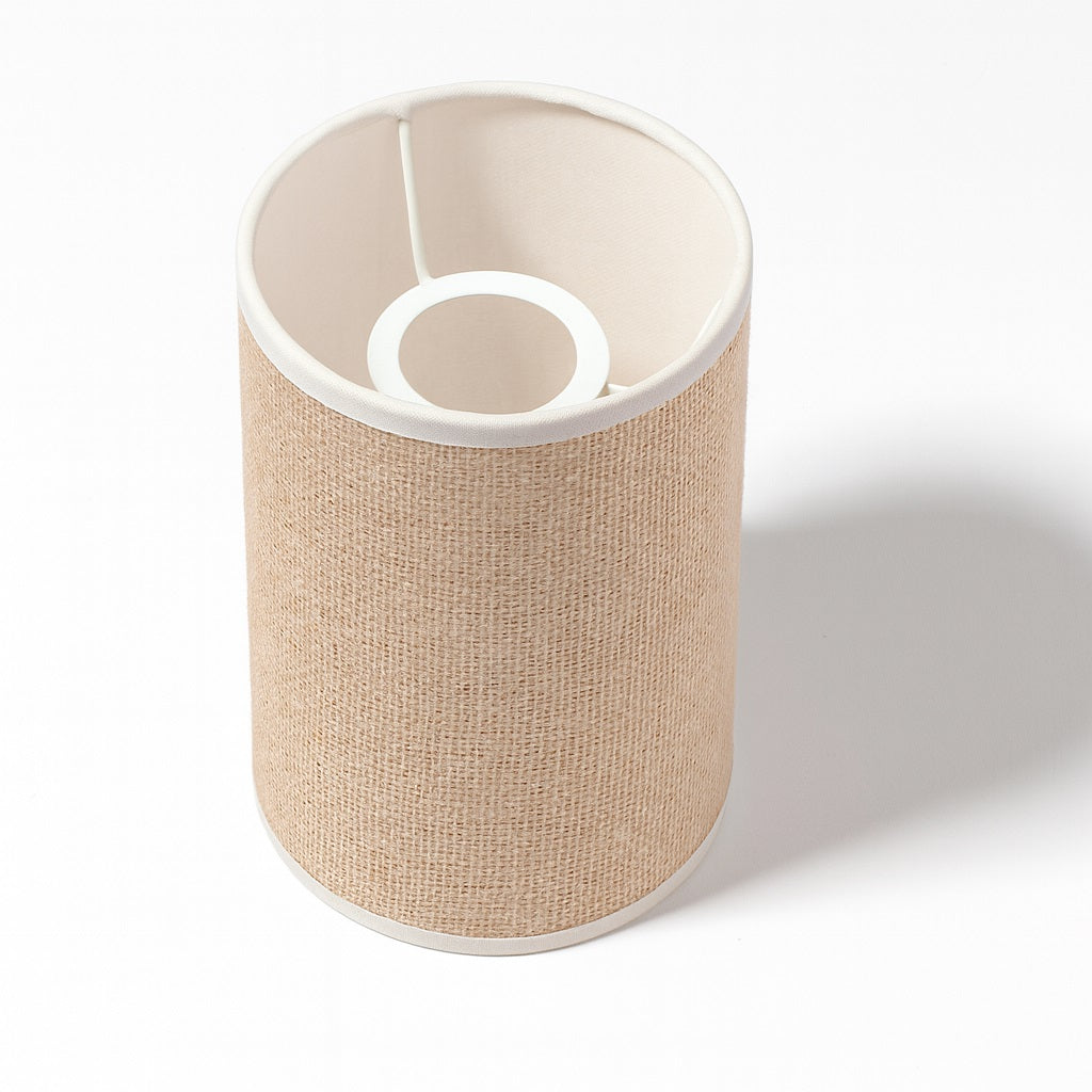 Vue en angle d’un abat-jour cylindrique en tissu beige avec armature intérieure blanche