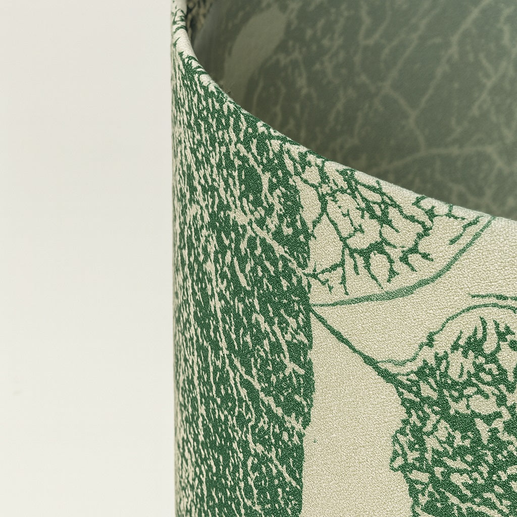 Zoom détaillé sur tissu d’abat-jour vert à motif feuilles, texture fine et finition haut de gamme.