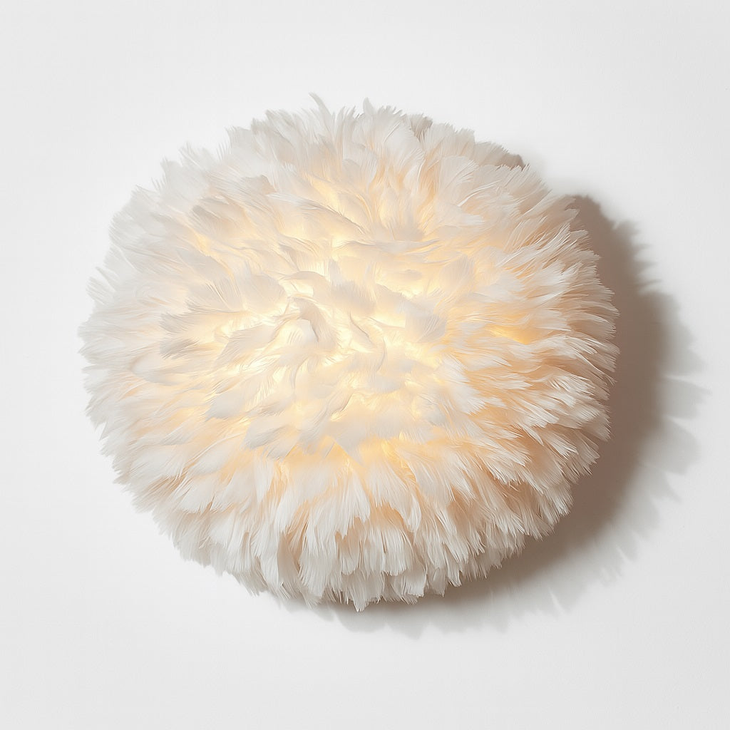 Applique murale en plumes blanches diffusant une lumière douce et chaleureuse, ambiance cocooning garantie.