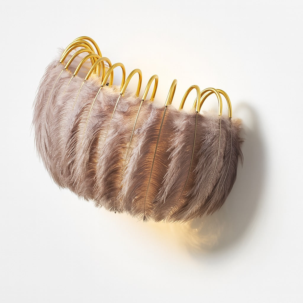 Vue en angle d'une applique plume brune sur structure dorée, lumière tamisée élégante.