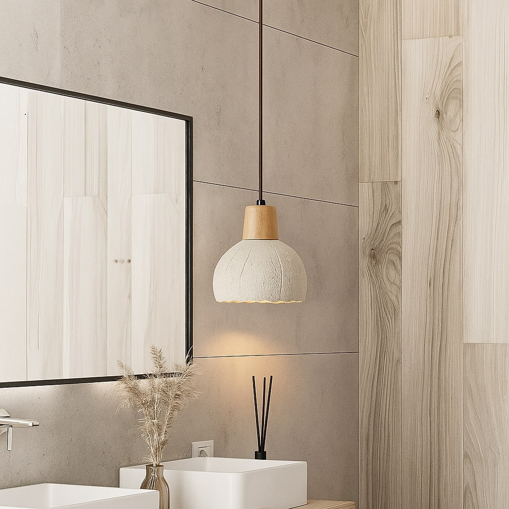 Suspension en ciment texturé au-dessus d’un meuble vasque, design naturel et lumière douce pour salle de bain épurée.