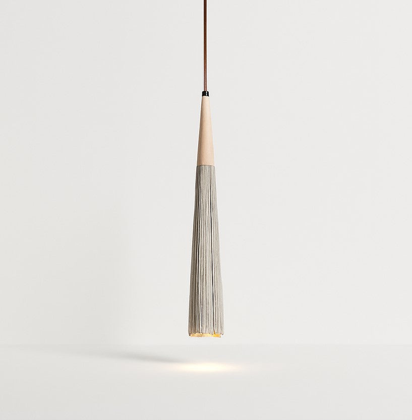 Suspension en ciment nervuré et bois clair, forme allongée et sculptée, lumière directionnelle et style organique minimaliste.