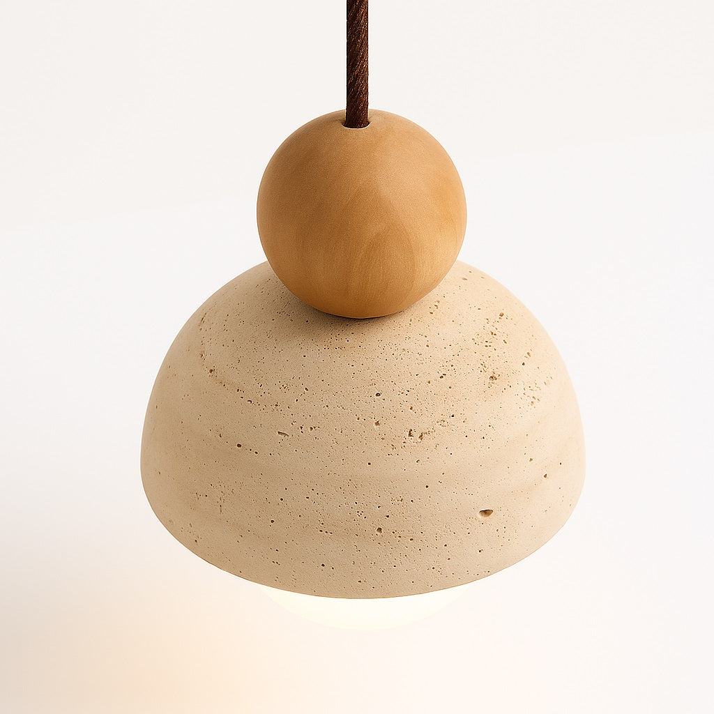 Vue en angle d’un abat-jour en pierre naturelle avec boule en bois et câble textile.