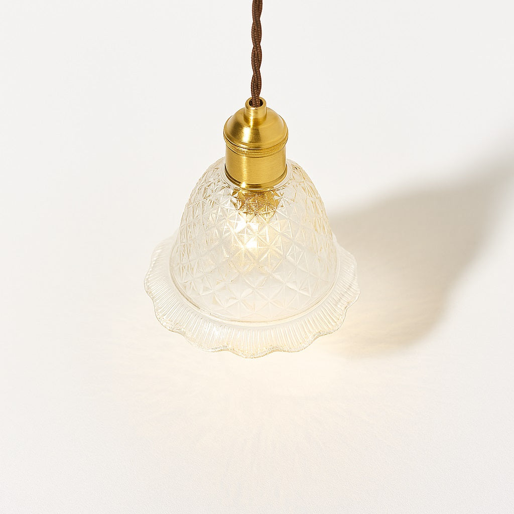Lampe suspendue vue du dessus à 45°, abat-jour cloche en verre taillé, reflets lumineux, douille laiton.