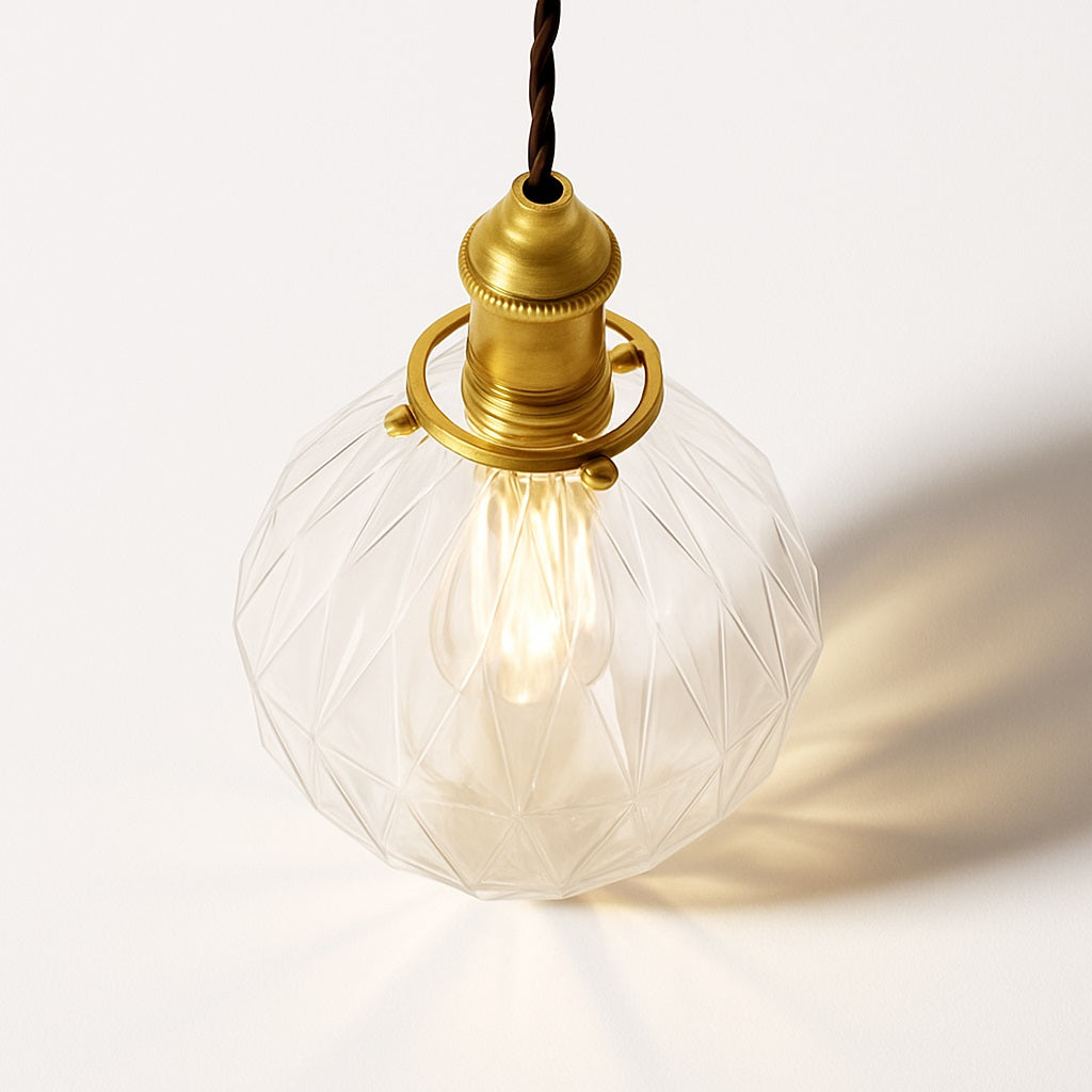 Vue plongeante d’un abat-jour en verre facetté transparent avec ampoule LED et monture en laiton vintage