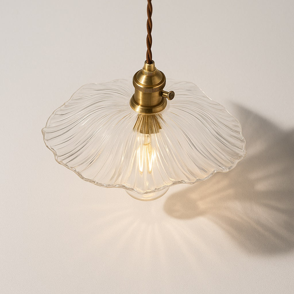 Lampe suspendue vue du dessus, abat-jour ondulé façon fleur en verre nervuré, douille laiton, lumière décorative.