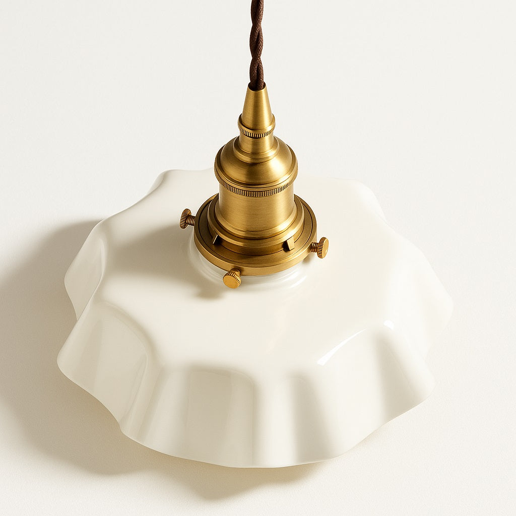 Vue plongeante d’un abat-jour en céramique blanche plissée avec douille dorée, suspension design style vintage.