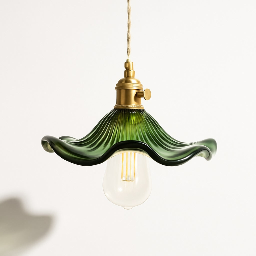 Suspension avec abat-jour en verre ondulé vert, style organique, douille dorée et ampoule visible, design floral élégant.