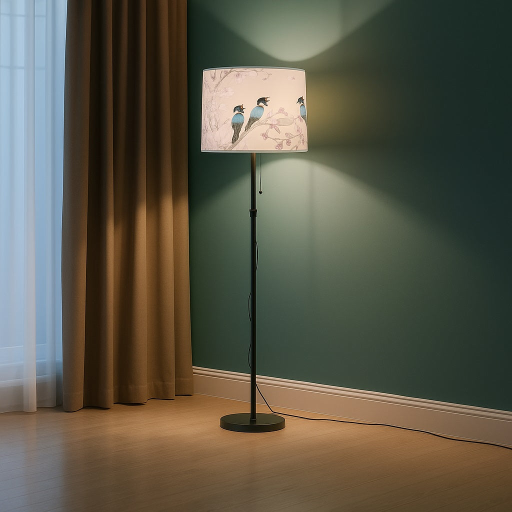 Lampadaire avec abat-jour Aubeline rose à oiseaux bleus créant une lumière douce et poétique dans le salon.