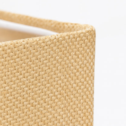 Gros plan sur le tissu d’un abat-jour carré fauve, texture tissée naturelle pour abat-jour lampadaire élégant.