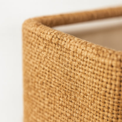 Gros plan sur le tissu d’un abat-jour carré safran, texture tissée naturelle pour abat-jour lampadaire élégant.