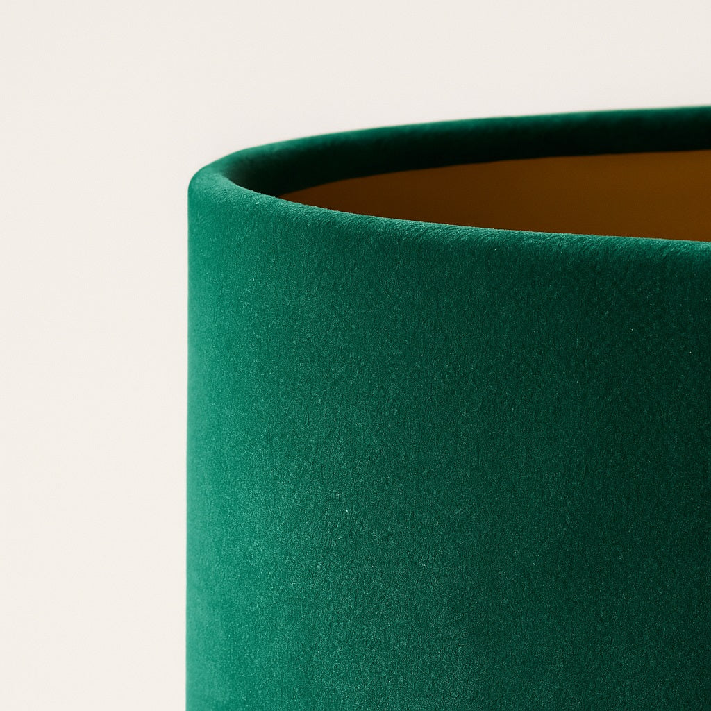 Abat-jour en velours vert pour lampe, texture douce et reflet naturel, photo haute qualité fond clair studio.