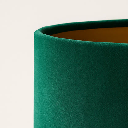 Abat-jour en velours vert pour lampe, texture douce et reflet naturel, photo haute qualité fond clair studio.