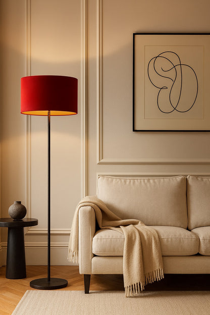 Lampadaire habillé d’un abat-jour ovale en velours rouge Rubinia, créant une atmosphère élégante et cosy dans un salon contemporain.