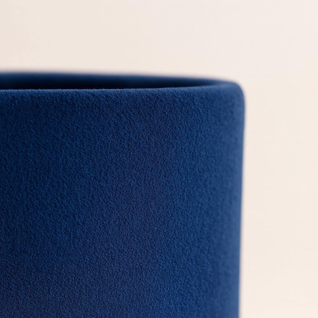 Détail d’un abat-jour en velours bleu profond, intérieur doré, texture douce et finition élégante pour lampe design.