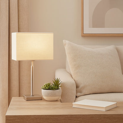 Lampe de chevet avec abat-jour rectangulaire en tissu beige, ambiance chaleureuse et moderne pour séjour.