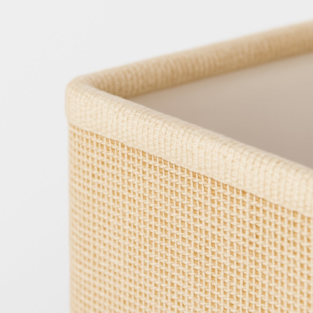 Abat-jour rectangle beige posé sur lampe dorée dans salon lumineux, style contemporain.