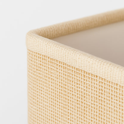 Abat-jour rectangle beige posé sur lampe dorée dans salon lumineux, style contemporain.