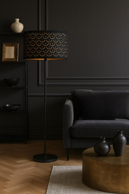 Lampadaire avec abat-jour tambour noir et doré, apportant une touche chic et chaleureuse au salon.