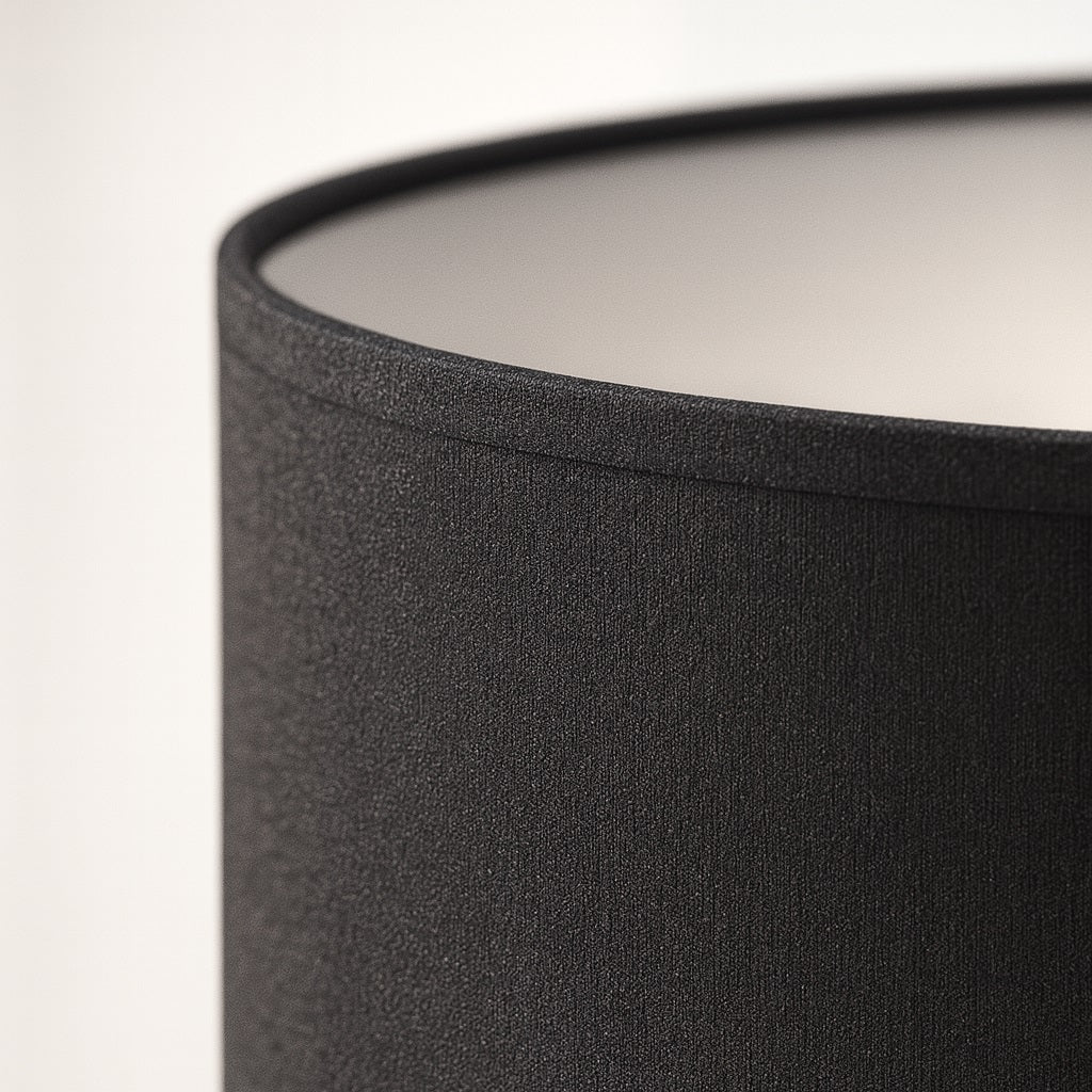 Gros plan sur un abat-jour noir tambour, texture élégante et finition soignée pour lumière contemporaine.