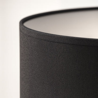 Gros plan sur un abat-jour noir tambour, texture élégante et finition soignée pour lumière contemporaine.