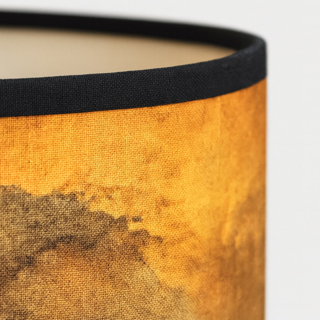 Zoom sur un abat-jour aux tons dorés, texture détaillée pour lampadaire design et décoration intérieure.
