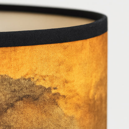 Zoom sur un abat-jour aux tons dorés, texture détaillée pour lampadaire design et décoration intérieure.