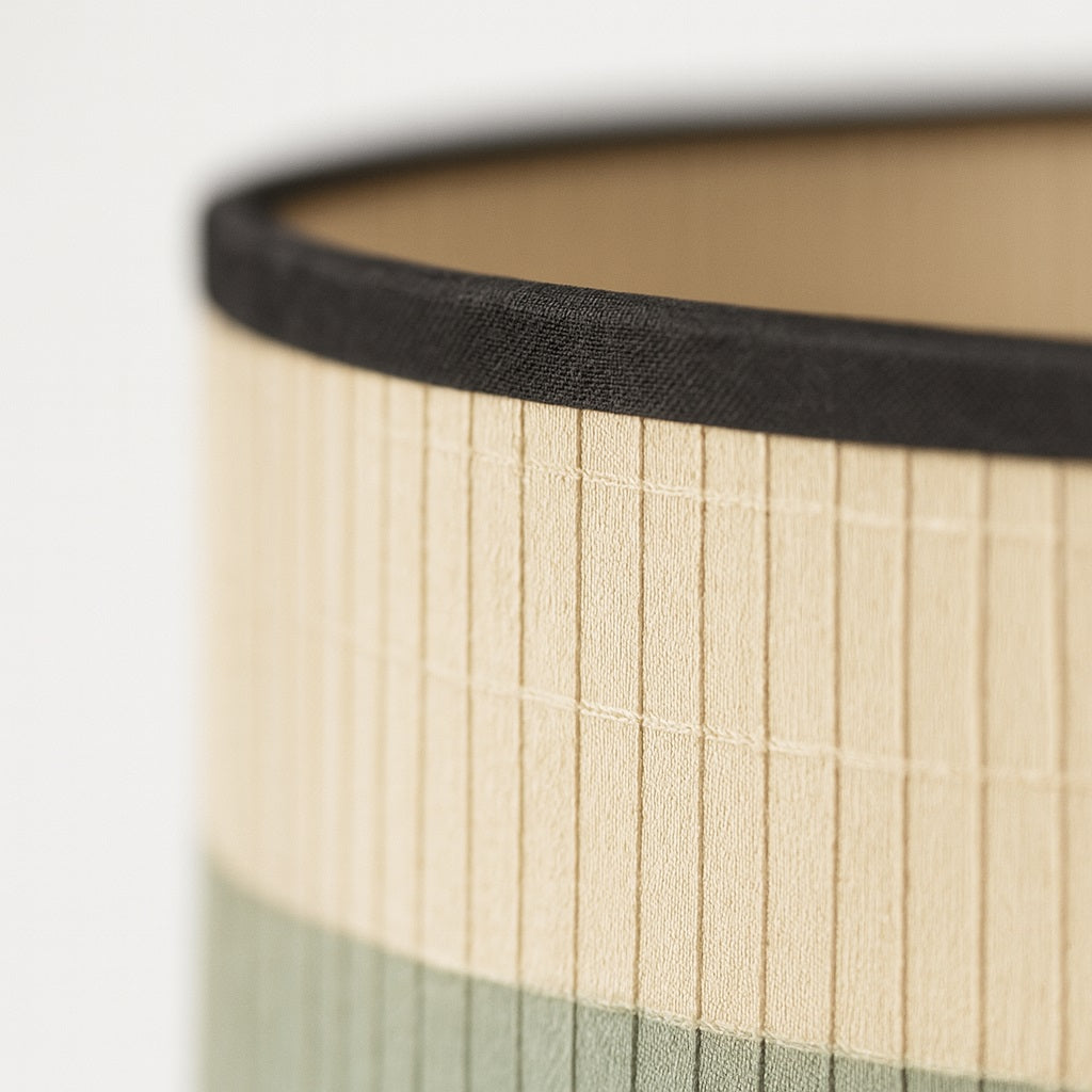 Zoom sur un abat-jour aux fines lames et couleurs douces, parfait comme abat-jour lampadaire élégant.