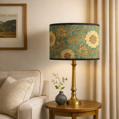 Abat-jour vert et or sur pied doré, lumière douce et design floral raffiné pour un salon lumineux et apaisant.