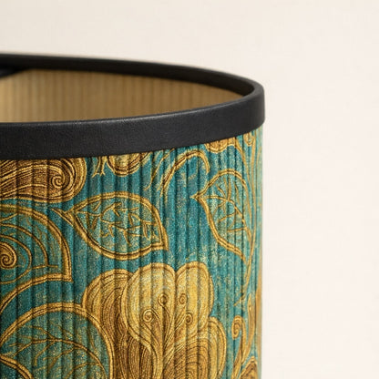 Zoom sur tissu d’abat-jour vert à motifs dorés, texture fine et reflets lumineux haut de gamme.