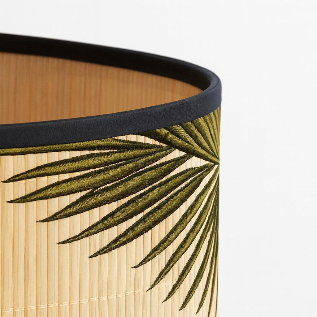 Détail d’un abat-jour en bambou tressé avec broderie feuillage vert, finition noire élégante et artisanale.