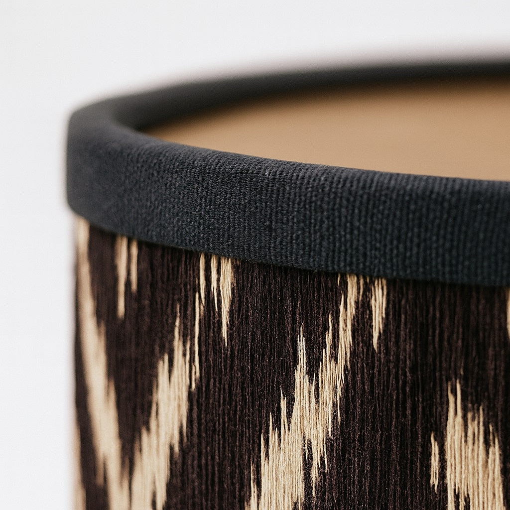 Zoom sur tissu d’abat-jour lampe noir et beige, texture détaillée et finition haut de gamme.