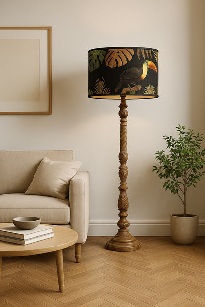 Lampe sur pied avec abat-jour noir motif toucan, décor tropical élégant dans un salon beige et bois clair.