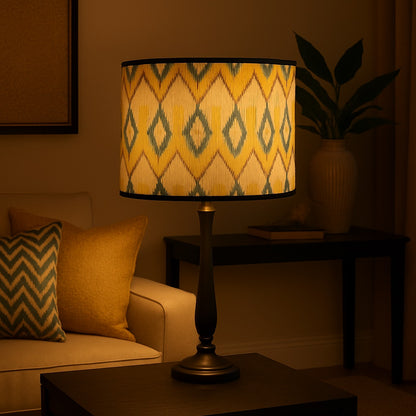 Abat-jour lampe éclairé au motif jaune et bleu, posé dans un salon cosy pour une ambiance douce et chaleureuse.