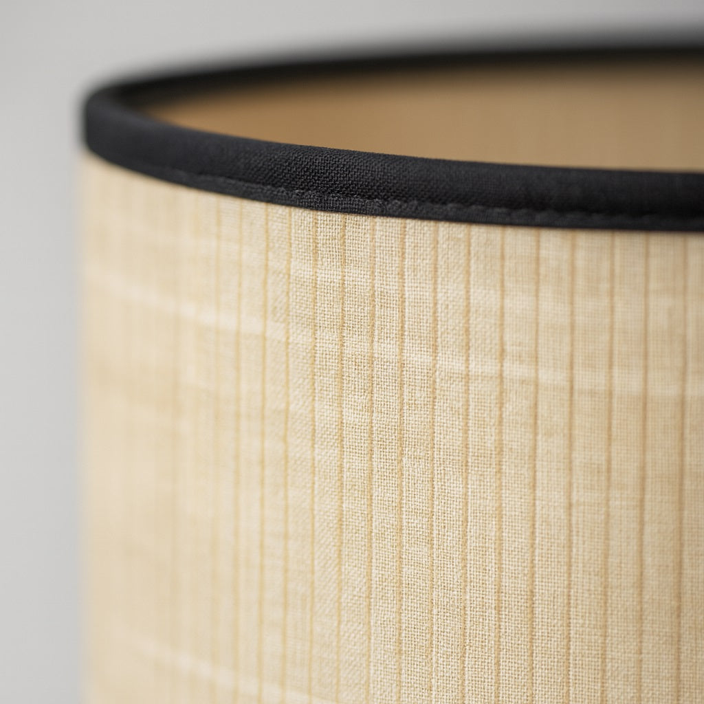 Zoom sur un abat-jour en fibres naturelles, texture fine idéale pour un lampadaire élégant et intemporel.