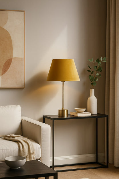 Abat-jour en velours jaune sur lampe dorée, intégré dans un salon moderne et élégant au décor épuré.