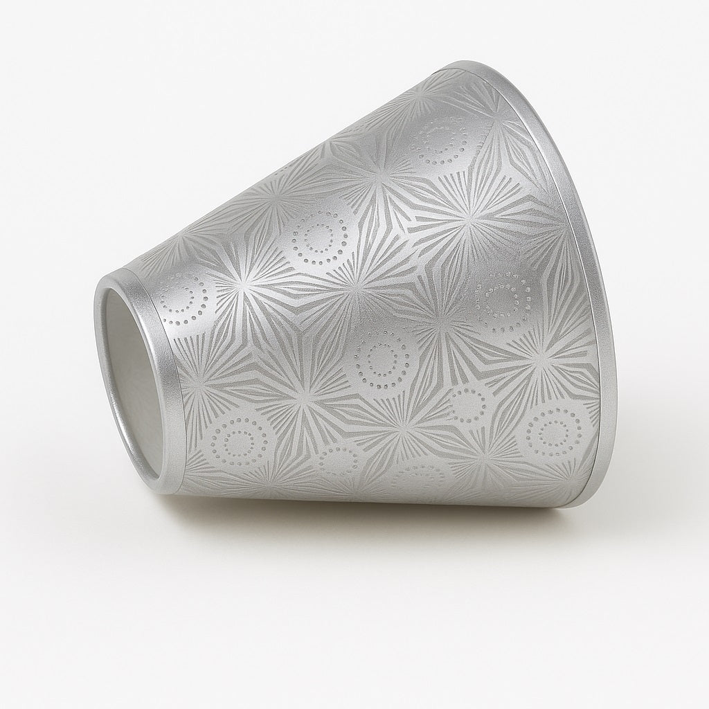 Abat-jour conique argenté posé sur le côté, abat-jour lampe de chevet à motifs géométriques.
