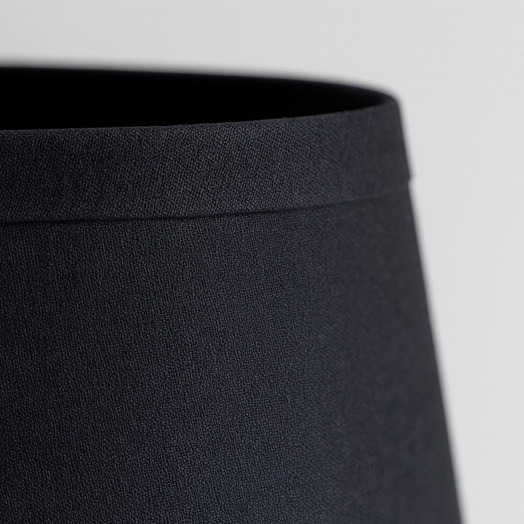 Zoom tissu noir d’un abat-jour conique, abat-jour lampe de chevet élégant au rendu moderne et raffiné.
