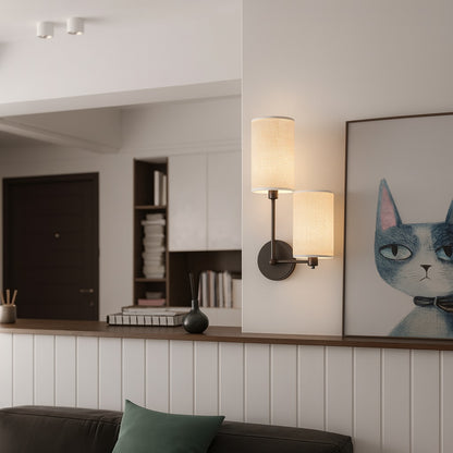 Abat-jour en tissu blanc diffusant une lumière douce sur des appliques murales dans un salon moderne