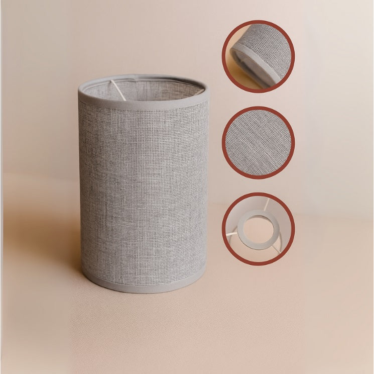 Détails d’un abat-jour en tissu gris, texture tramée et finition soignée avec cerclage discret