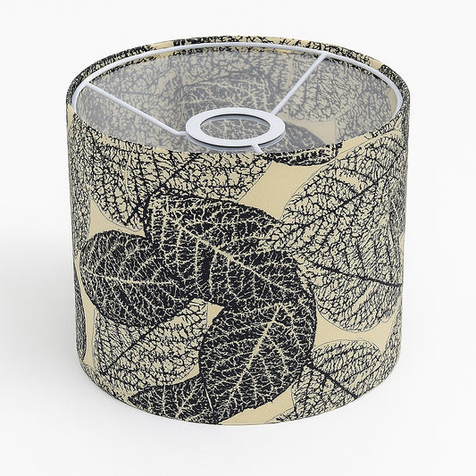 Abat-jour cylindrique en tissu beige décoré de feuilles noires, vue du dessus montrant la structure métallique intérieure.