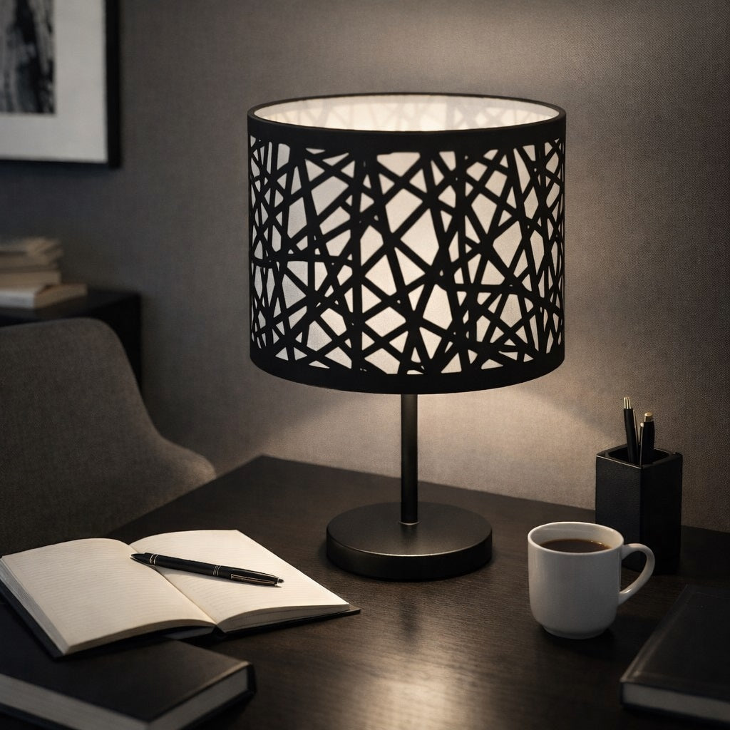 Abat-jour métal noir ajouré posé sur un bureau, design moderne et éclairage d’ambiance
