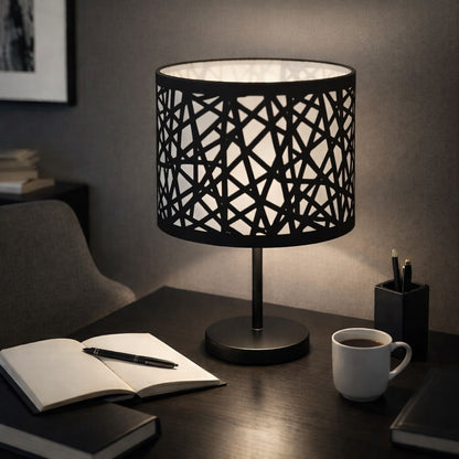 Abat-jour métal noir ajouré posé sur un bureau, design moderne et éclairage d’ambiance