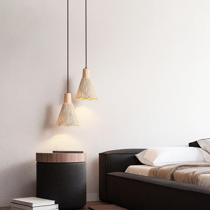 Duo de suspensions Trunco en ciment nervuré et bois clair, lumière douce au-dessus d’une table de nuit dans une chambre zen.