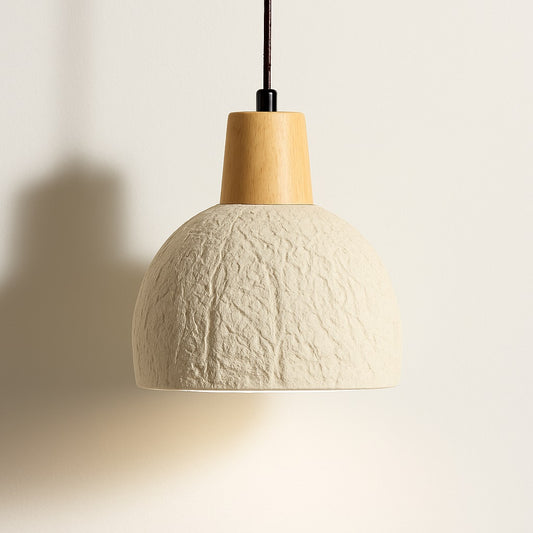Lampe suspension en ciment texturé et bois clair, lumière douce vers le bas, design organique et style naturel contemporain.