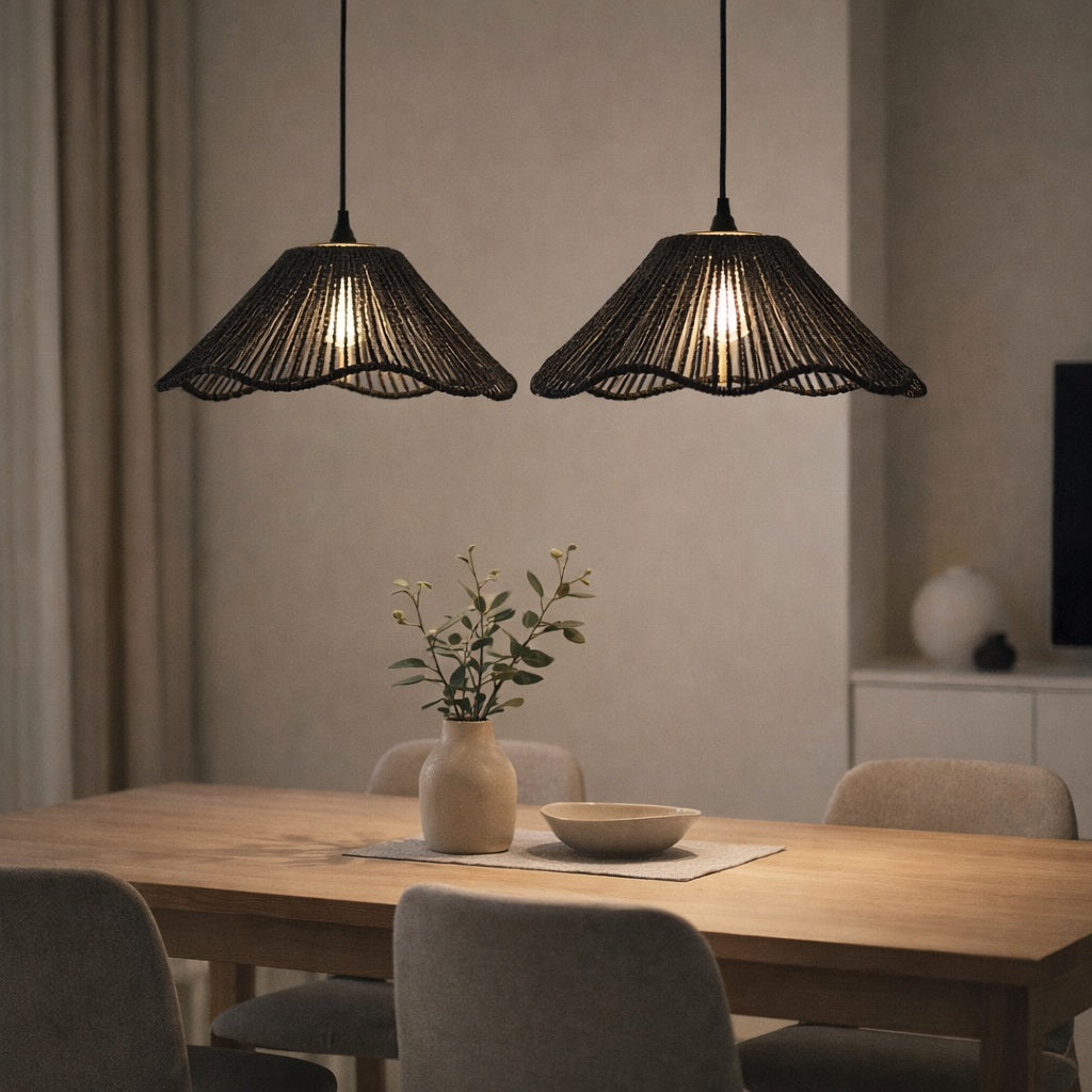Abat-jour suspensions noires au-dessus d’une table à manger, style moderne et chaleureux, éclairage tamisé.