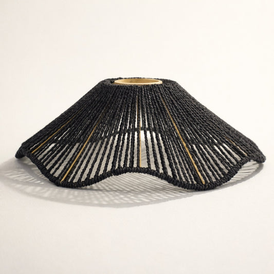 Abat-jour suspension en corde tressée noire, forme organique ajourée, abat-jour design diffusant une lumière douce.